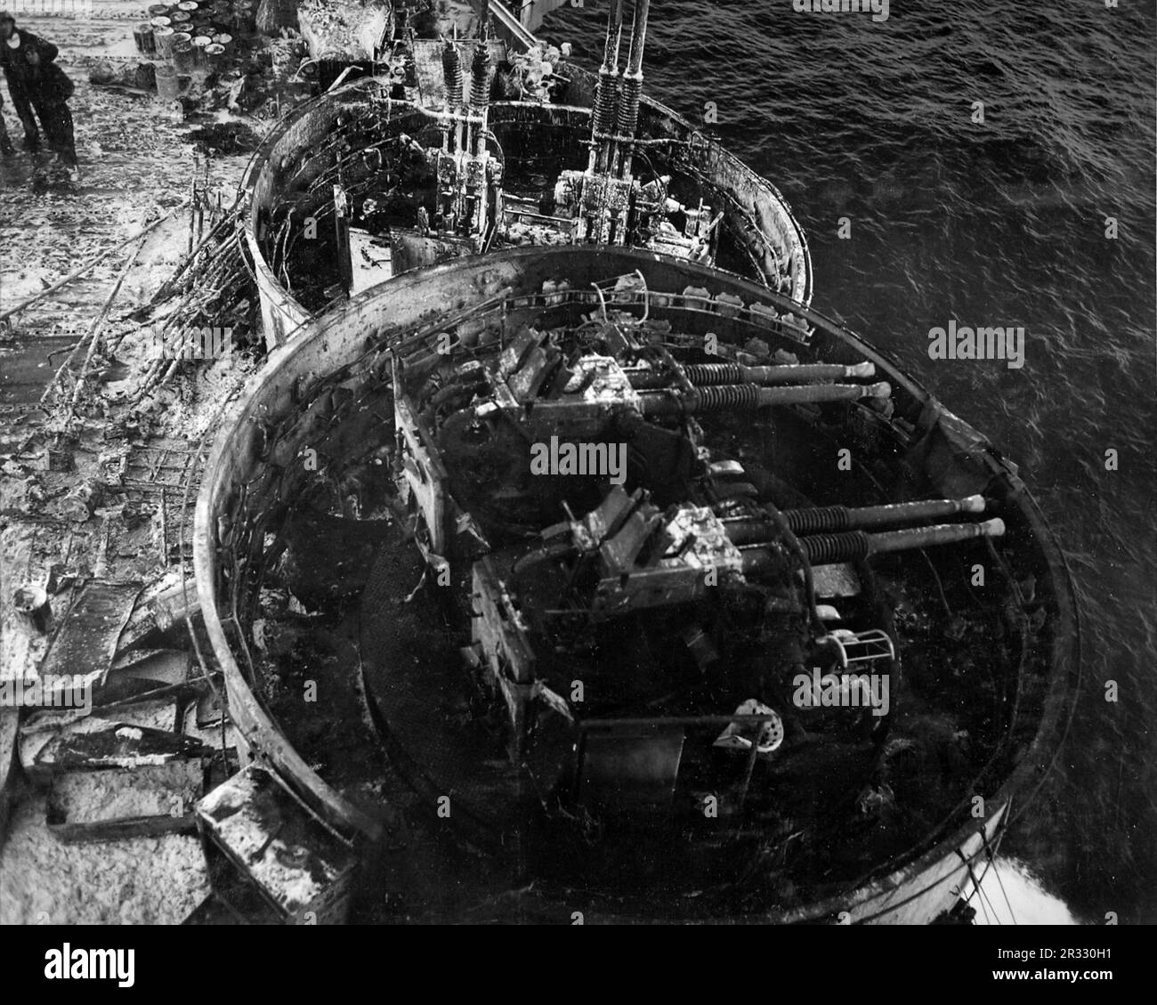 Vista del flak di Bofors 40 mm bruciato di fronte all'isola a bordo degli Stati Uniti Portaerei Navy USS Enterprise (CV-6), nel 1945. La foto è stata scattata dopo l'attacco kamikaze del 14 maggio 1945. Quando il Giappone stava affrontando la sconfitta alla fine del 1944 ha scelto di distruggere le navi statunitensi con attentati suicidi, noti come Kamikaze.questi attacchi erano una potente arma fisica e psicologica e affondarono un totale di 47 navi al costo di oltre 3000 piloti e aerei. Alla fine del 1944 la Marina americana era abbastanza grande da rendere le perdite insignificanti e non alterarono il corso della guerra. Foto Stock