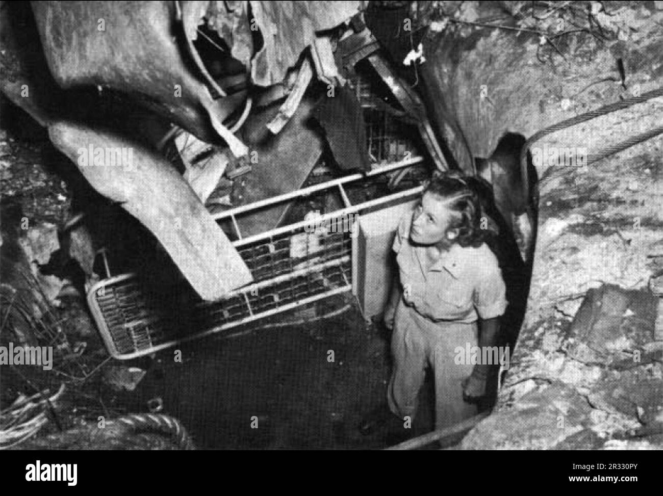 STATI UNITI L'infermiera dell'esercito osserva i danni a bordo degli Stati Uniti Nave Navy Hospital USS Comfort (AH-6). Dopo un viaggio a Subic Bay e nel Golfo di Lingayen, Luzon, per gli sfollati nel marzo 1945, la nave ospedaliera si fermò al largo di Okinawa dal 2 al 9 aprile, ricevendo feriti per l'evacuazione a Guam. Rientrato a Okinawa il 23 aprile, 6 giorni dopo fu colpita da un aereo suicida giapponese. L'aereo si è schiantato attraverso tre ponti che esplodono in chirurgia che è stato riempito di personale medico e pazienti. Le vittime sono state 28 morti (di cui sei infermieri) e 48 feriti, con danni considerevoli alla nave. Il comfort era stato ottimo Foto Stock