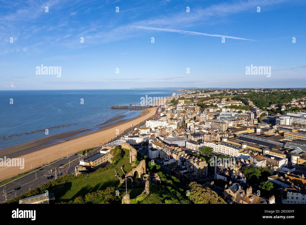 Hastings dall'aria con il Castello di Hastings e il Molo di Hastings in lontananza che mostrano la spiaggia in una giornata estiva Foto Stock