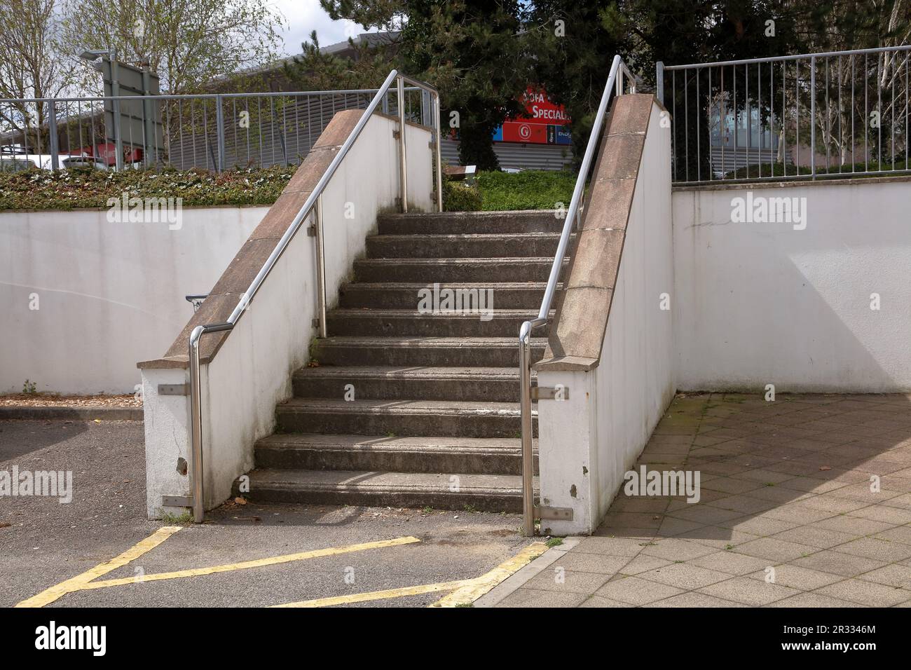 Una serie di gradini in cemento che consentono l'accesso tra i negozi nell'area industriale di Bridgend attraverso una strada molto trafficata. Foto Stock