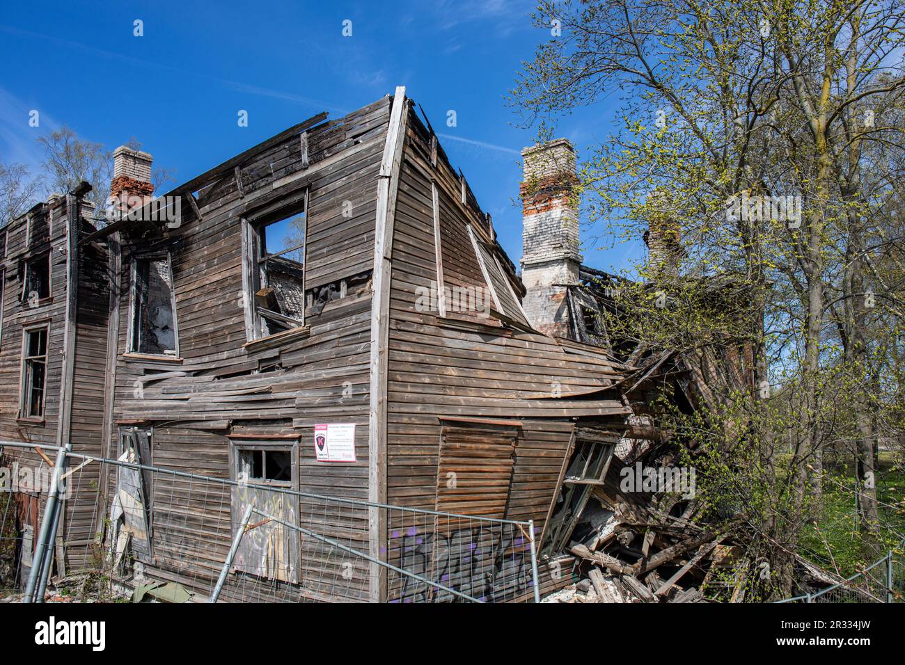 Edificio residenziale in legno parzialmente bruciato e crollato in una soleggiata giornata primaverile nel quartiere Kopli di Tallinn, Estonia Foto Stock