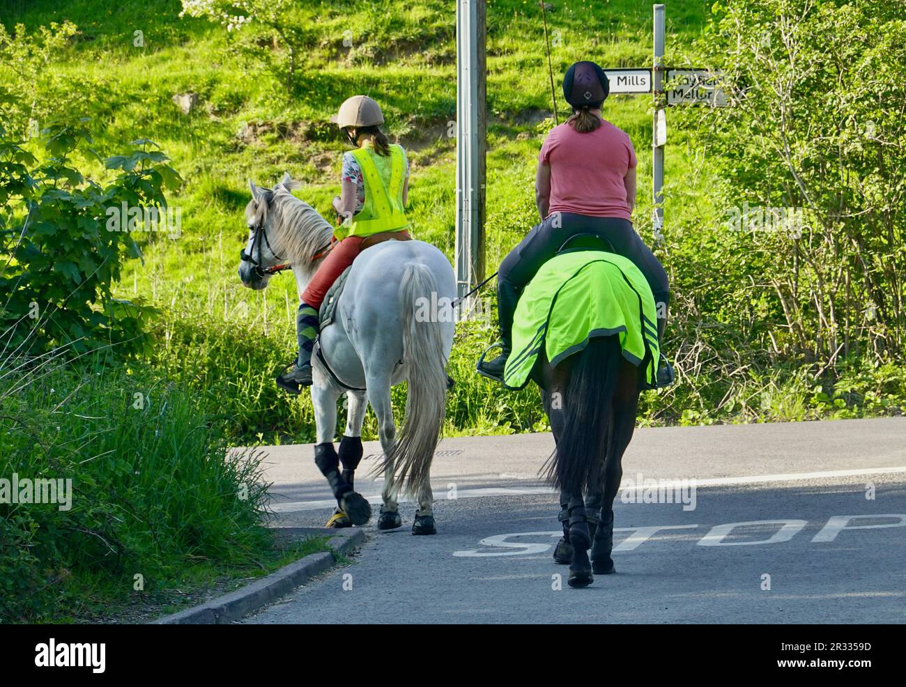 Due cavalieri femminili sulla strada a New Mills, Derbyshire Foto Stock