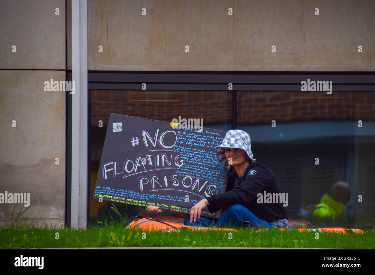 Londra, Regno Unito. 22nd maggio 2023. Un attivista dell'organizzazione pro-rifugiati rivendica il mare siede in una barca gonfiabile nella caratteristica dell'acqua fuori dell'ufficio domestico per protestare contro la chiatta migrante di Stoccolma Bibby. Credit: Vuk Valcic/Alamy Live News Foto Stock