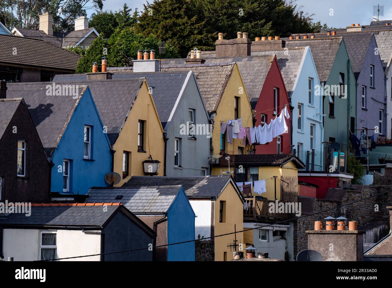 Una casa colorata sulla strada della città irlandese di Cobh, paesaggio urbano. Accogliente architettura europea. La lavanderia viene asciugata su un mantello. Foto Stock