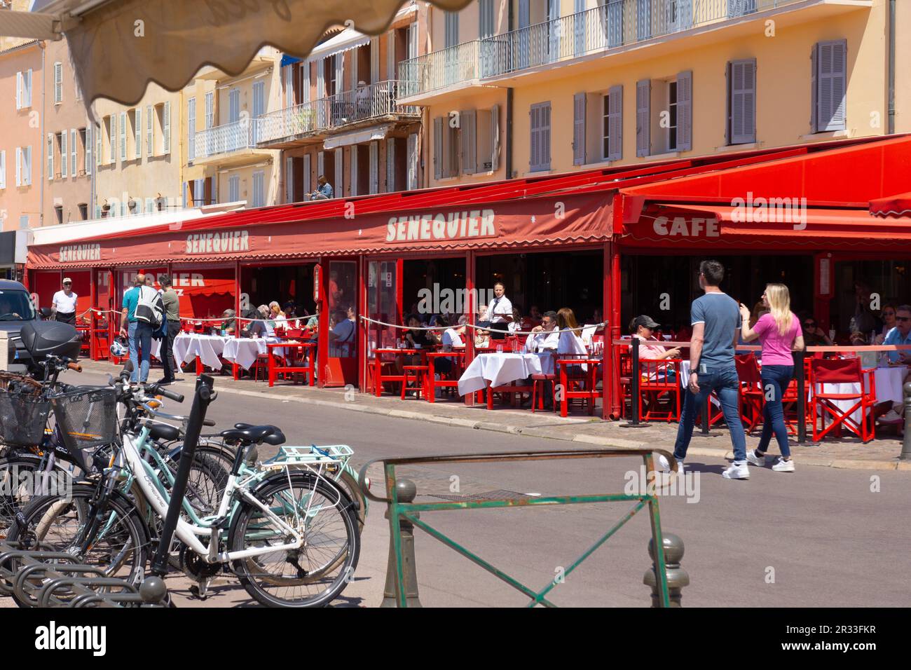Il caffè Senequier sul porto è popolare tra i turisti a Saint Tropez, Francia. Un elegante café di un ristoratore parigino attrae i proprietari di yacht e i turisti. Foto Stock