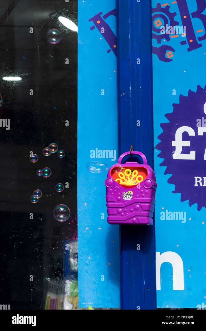 Soffiatore automatico di bolla di sapone appeso fuori negozio per attirare l'attenzione dei bambini. Foto Stock