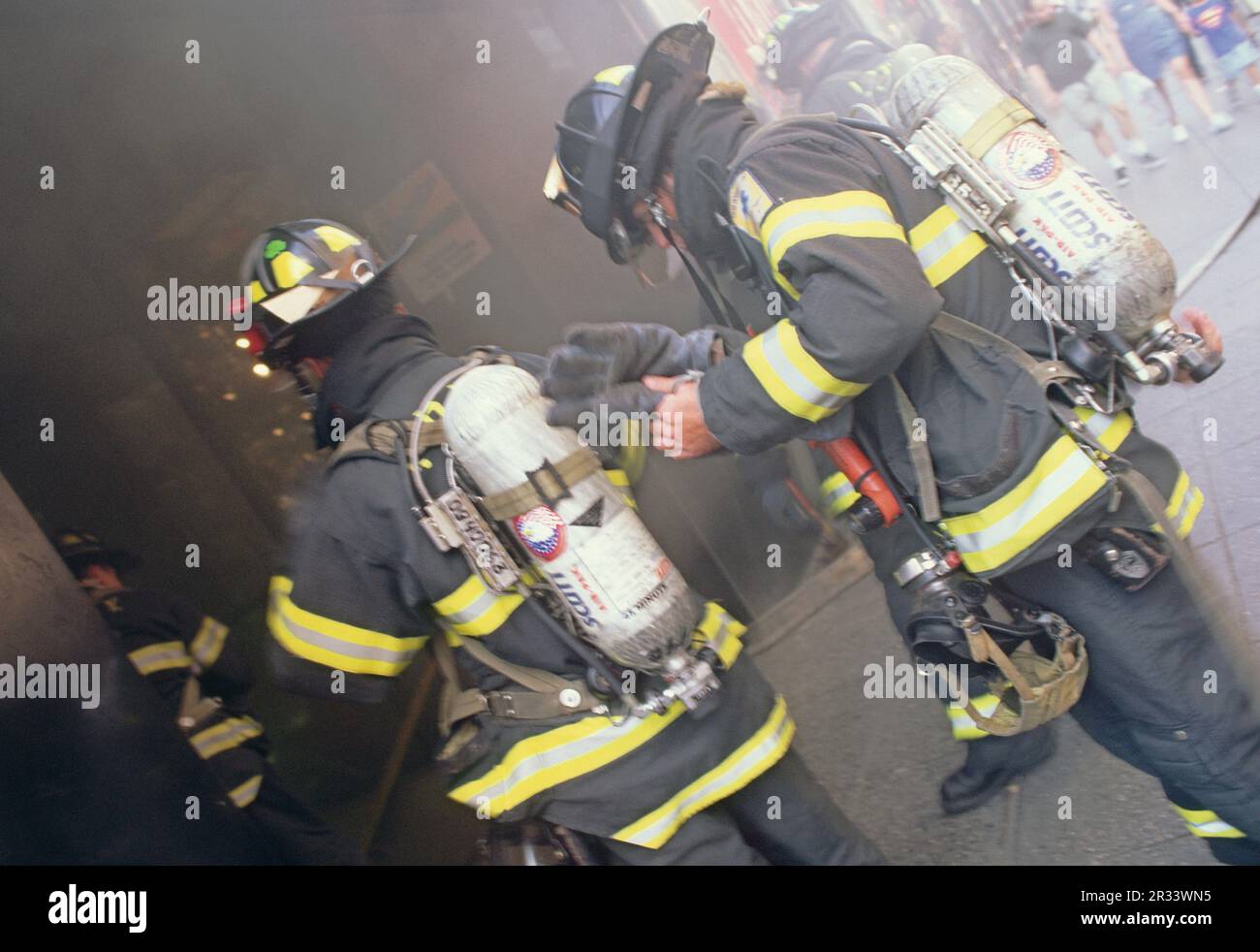 Vigili del fuoco o vigili del fuoco da vicino (primo piano) entrando nell'ingresso dell'edificio fumatori di New York City USA. Equipaggiamento da vigile del fuoco Foto Stock