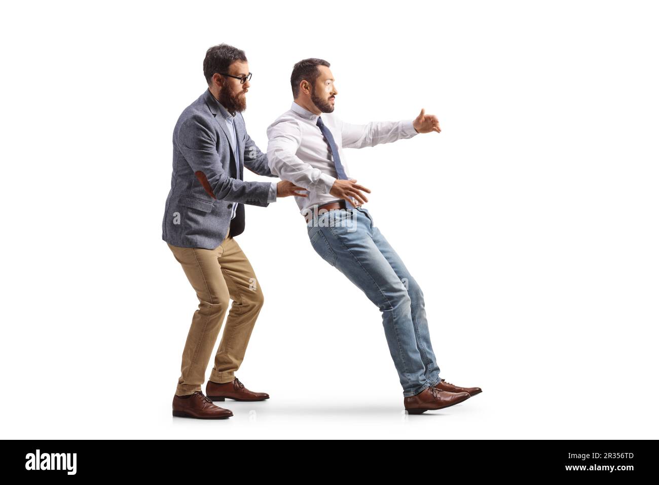 Profilo a tutta lunghezza girato di un uomo che cattura un altro uomo cadendo isolato su sfondo bianco Foto Stock