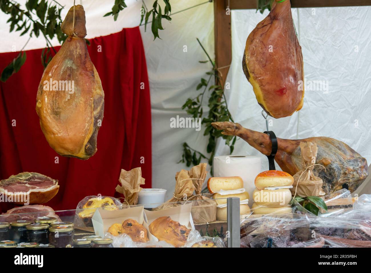 Prosciutto e formaggi esposti su una panchina. Prosciutti e salsicce, odori di prodotti fatti in casa. Cibi e sapori rurali e tradizionali portoghesi. Foto Stock