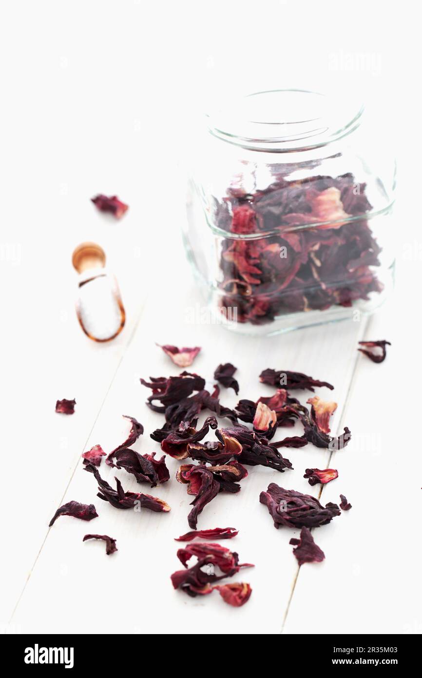 Fiori di ibisco secchi in vaso e su un panno bianco Foto Stock