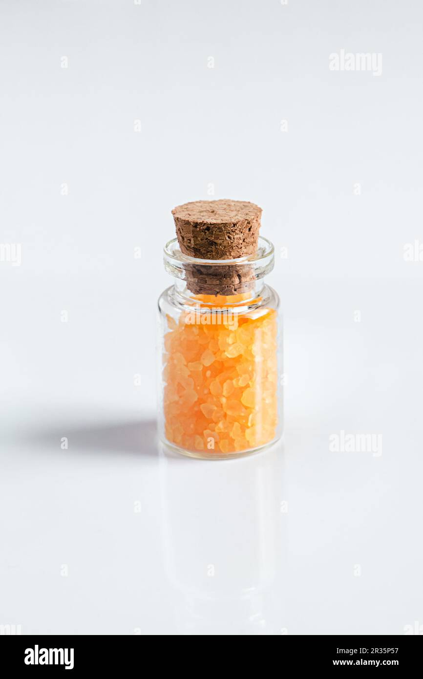 Bottiglia di vetro con sale da bagno su fondo bianco. Concetto di spa e aromaterapia. Foto Stock