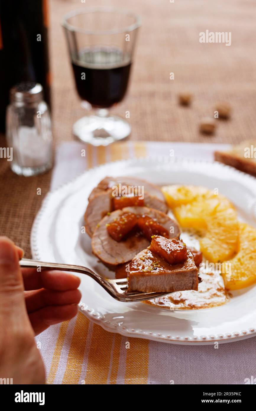 Filetto di maiale agrodolce con ananas caramellati e pistacchi Foto Stock