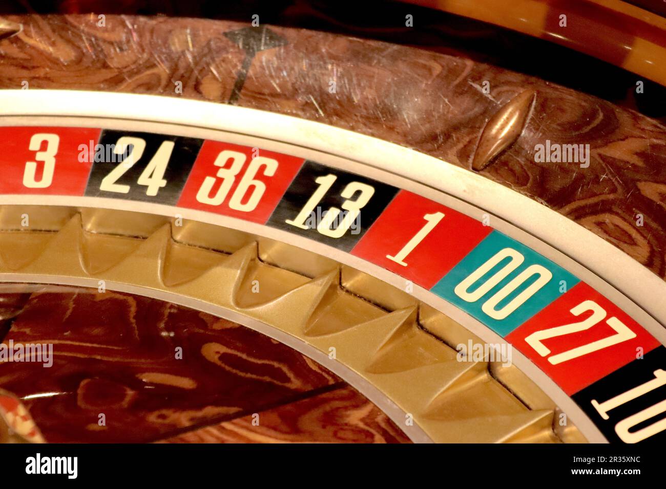 Doppio zero TCS ruota roulette Saturno stile americano primo piano, che illustra i numeri delle ruote e le tasche all'interno di impiallacciatura di legno ciotola surround, 2023. Foto Stock