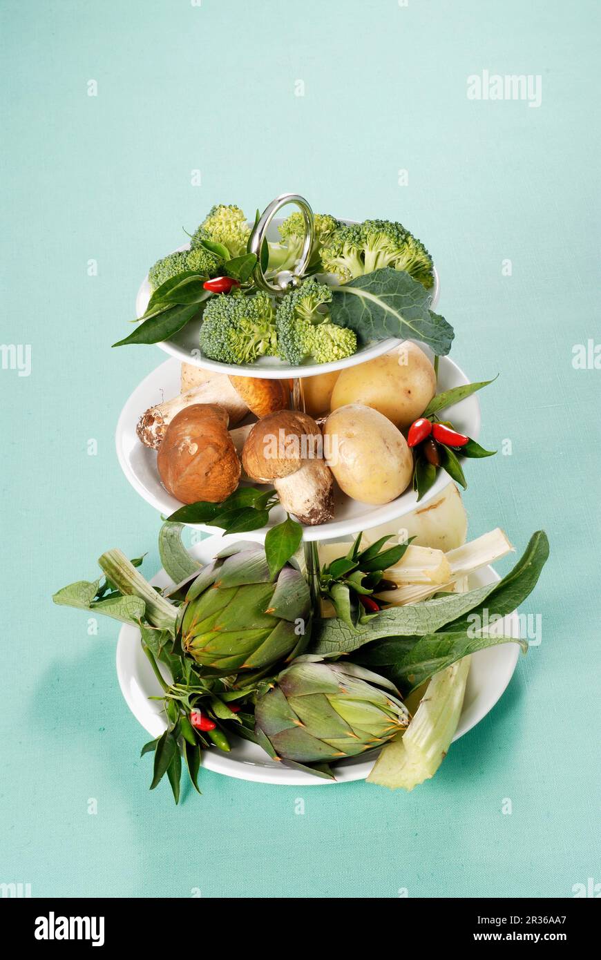 Varie le verdure su una torta di stand Foto Stock