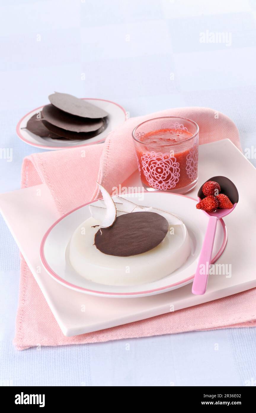 Gelatina di cocco con tini di cioccolato fondente e salsa di fragole selvatiche Foto Stock