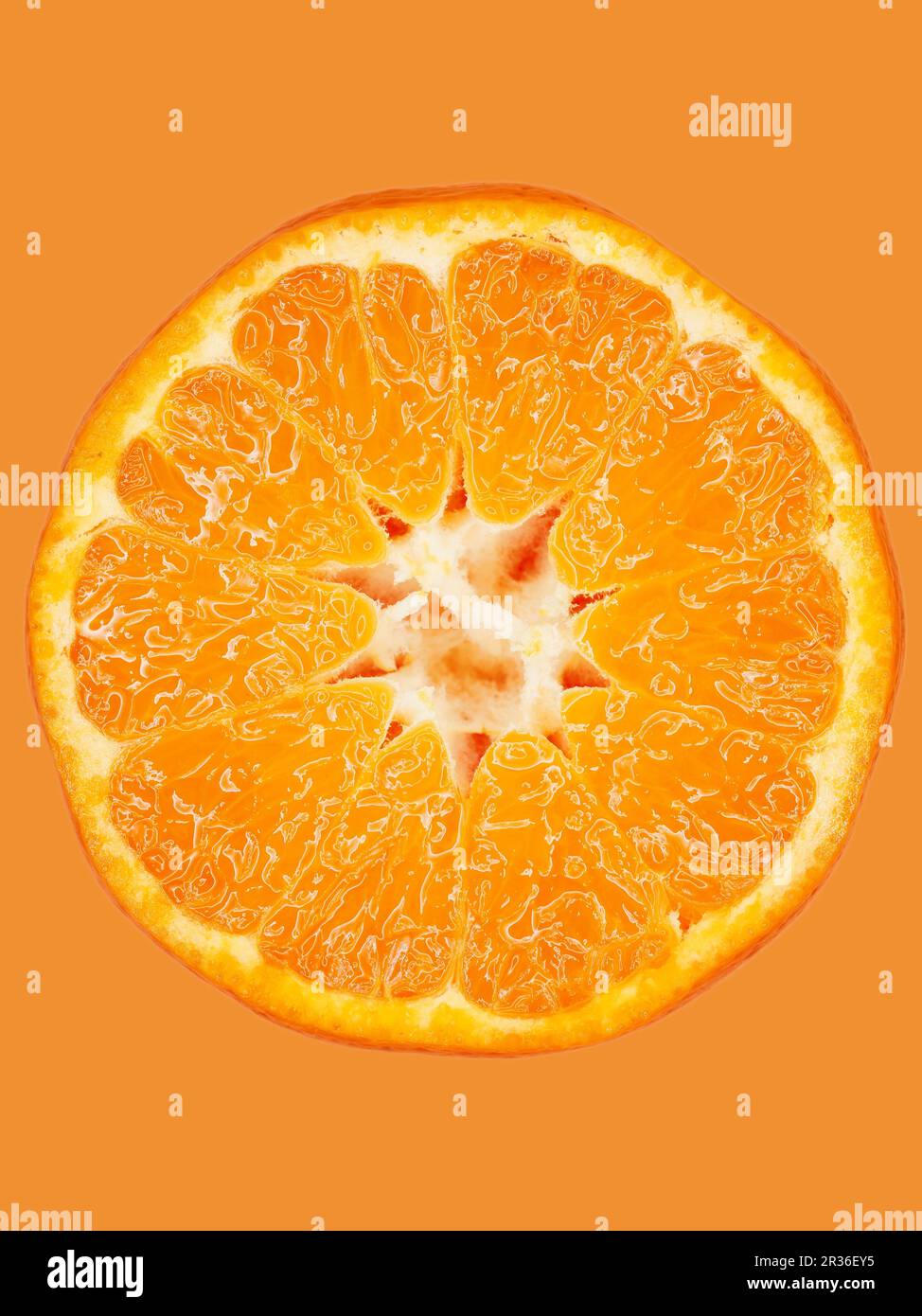 Una fetta di mandarino su una superficie arancione, primo piano Foto Stock