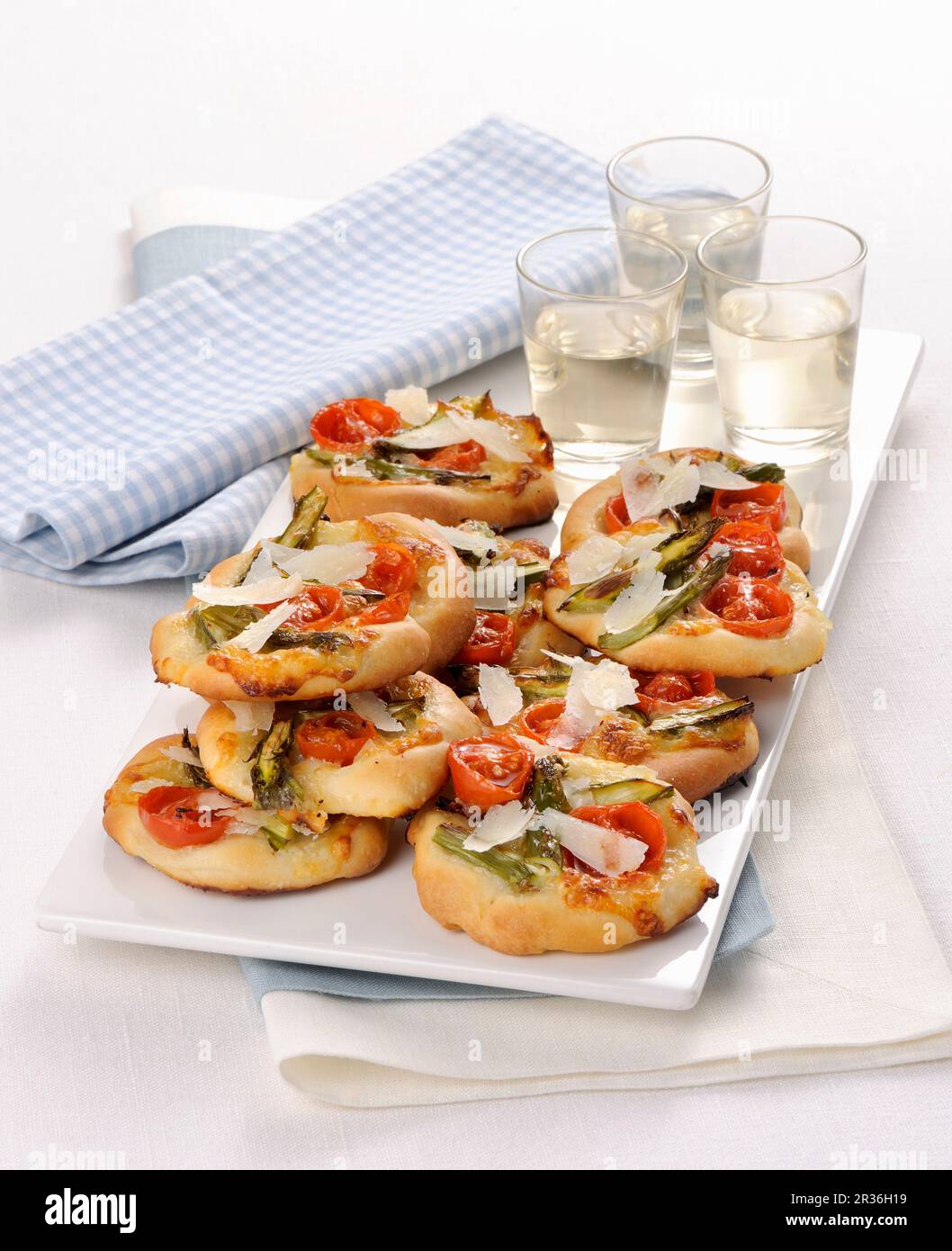 Mini pizze con asparagi verdi e pomodori ciliegini Foto Stock