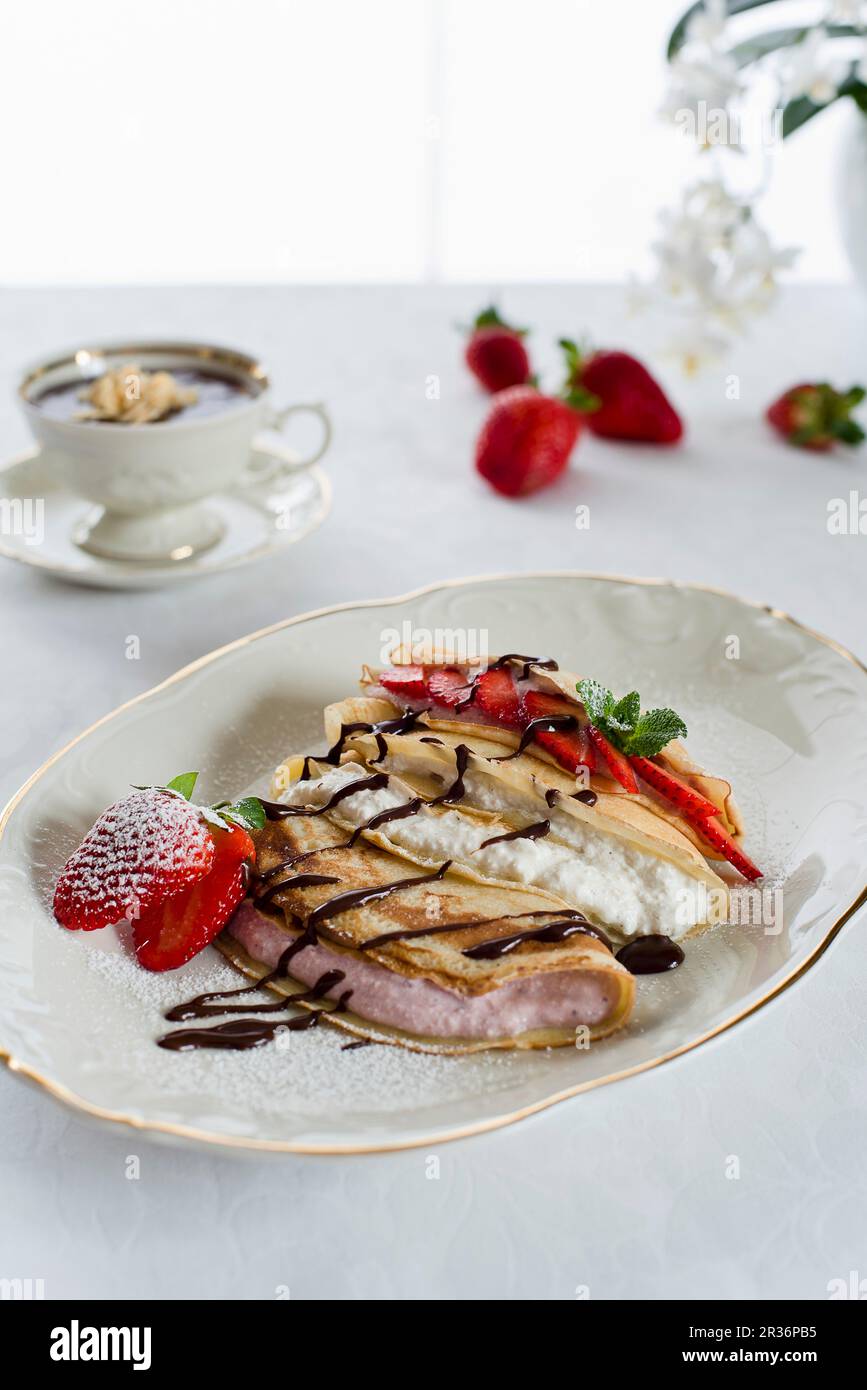 Frittelle con formaggio fresco, quark di frutti di bosco, frutta fresca e salsa al cioccolato Foto Stock