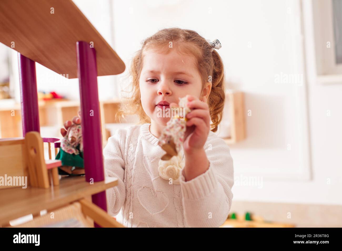 Ragazza che gioca con un dollhouse Foto Stock