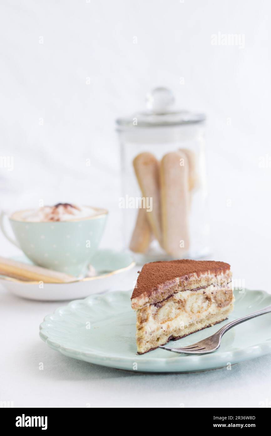 Una fetta di torta tiramisù e un cappuccino Foto Stock