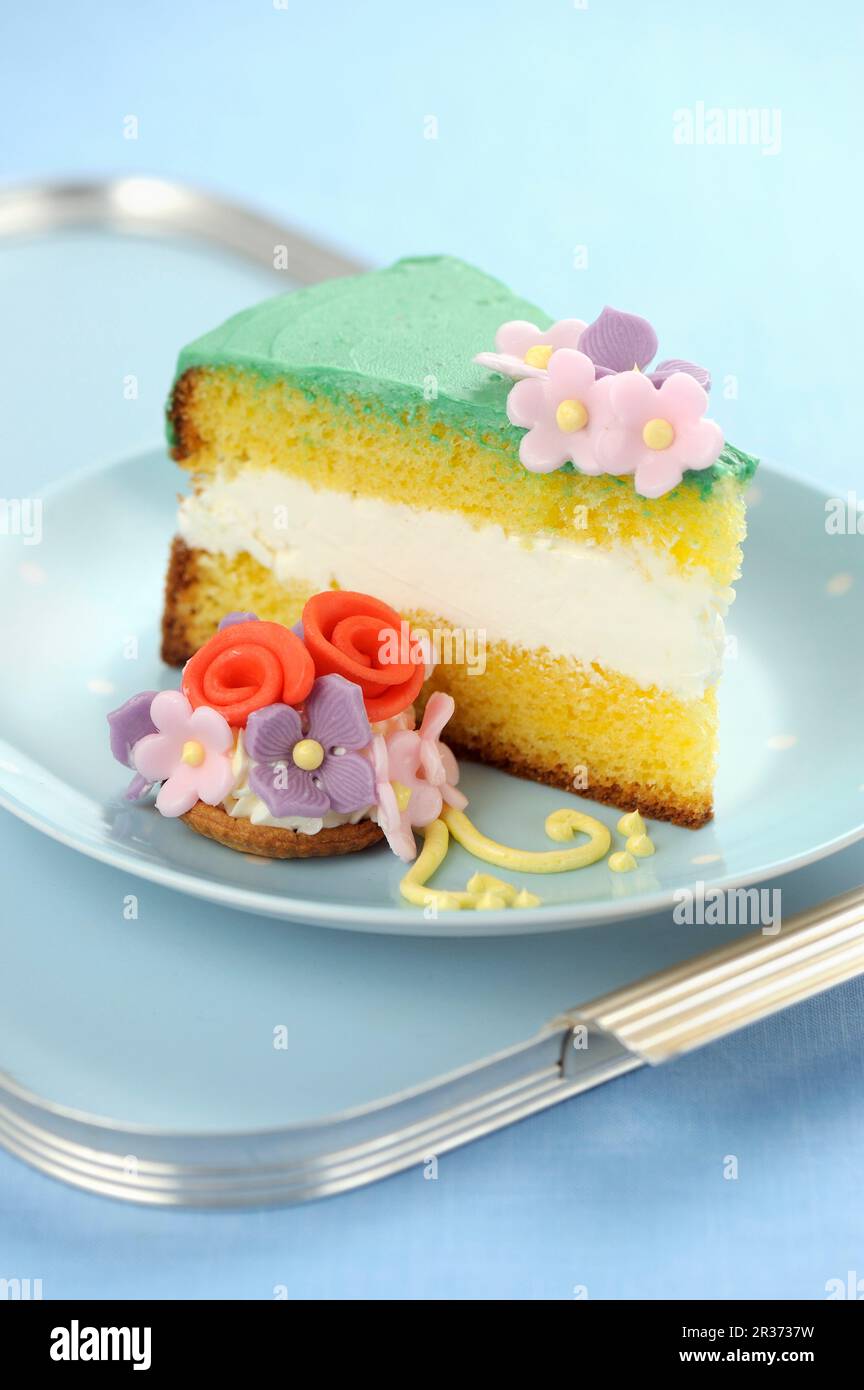 Un pezzo di torta genovese con fondente fiori Foto Stock