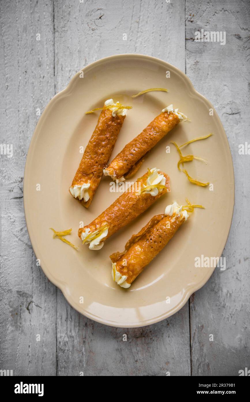 Tuilles di acquavite con crema di limone in piastra, vista dall'alto. Foto Stock