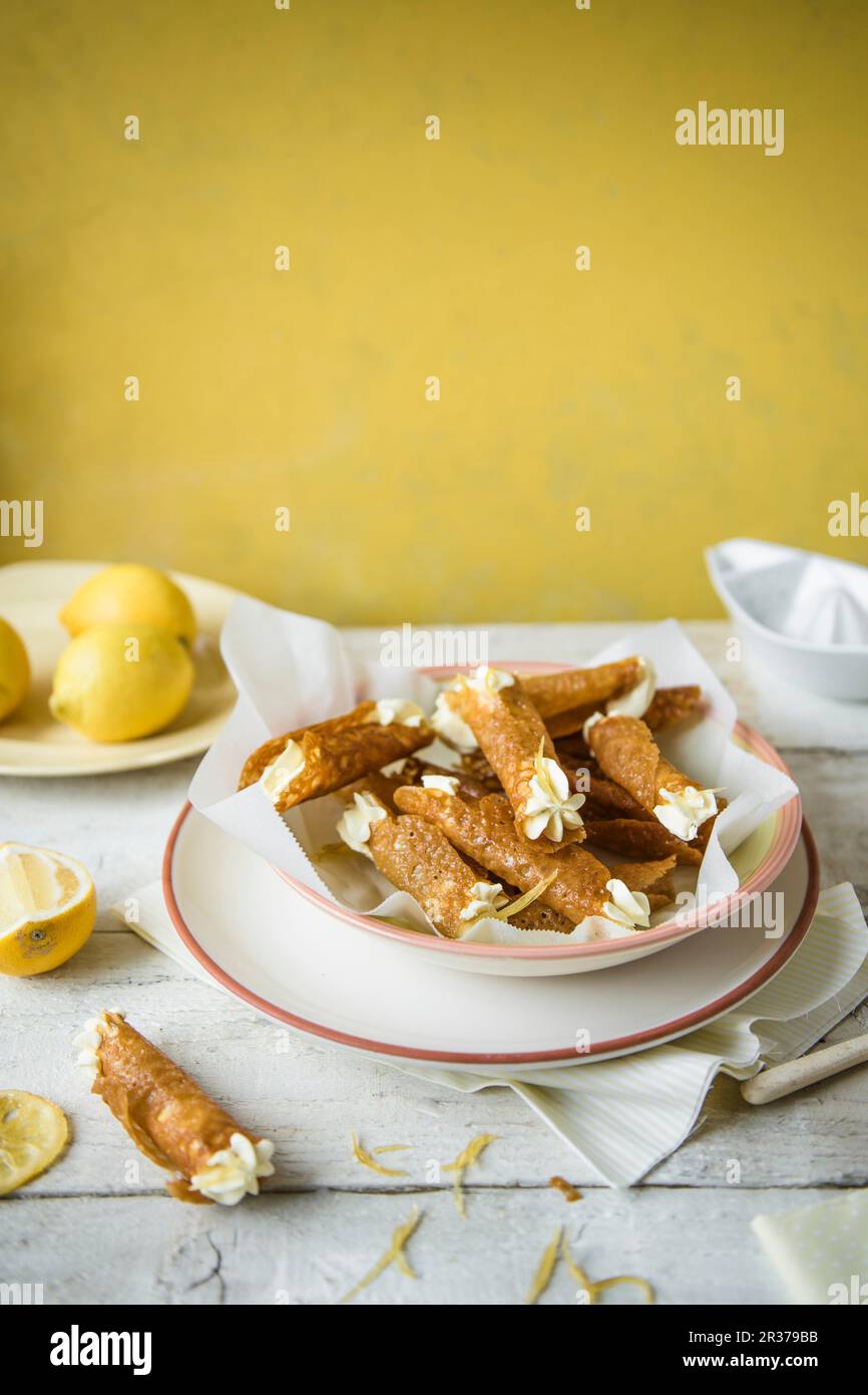 Tuilles di acquavite con crema di limone in una ciotola. Foto Stock