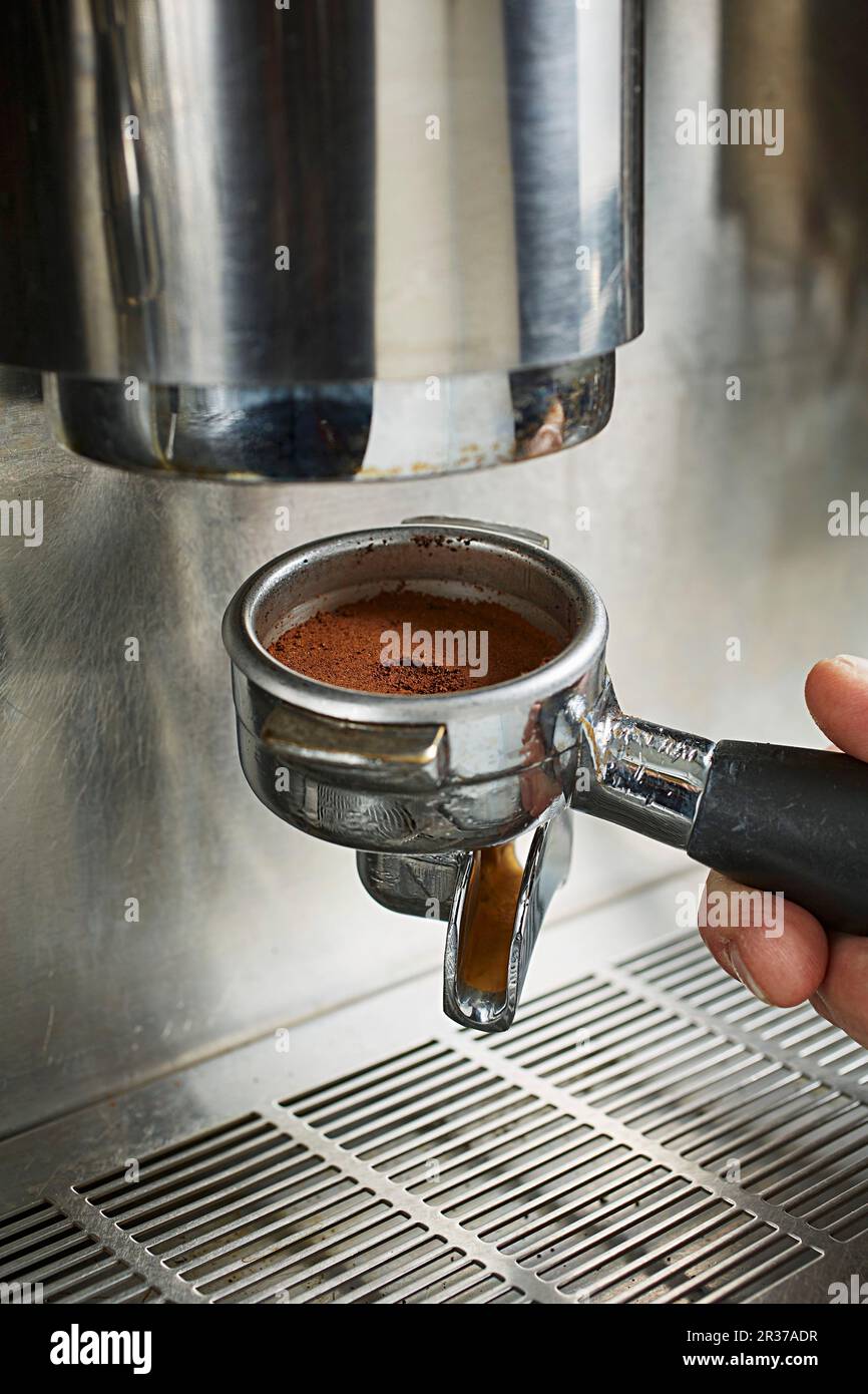 Collegare il portafiltro con il caffè appena macinato alla macchina da caffè  Foto stock - Alamy