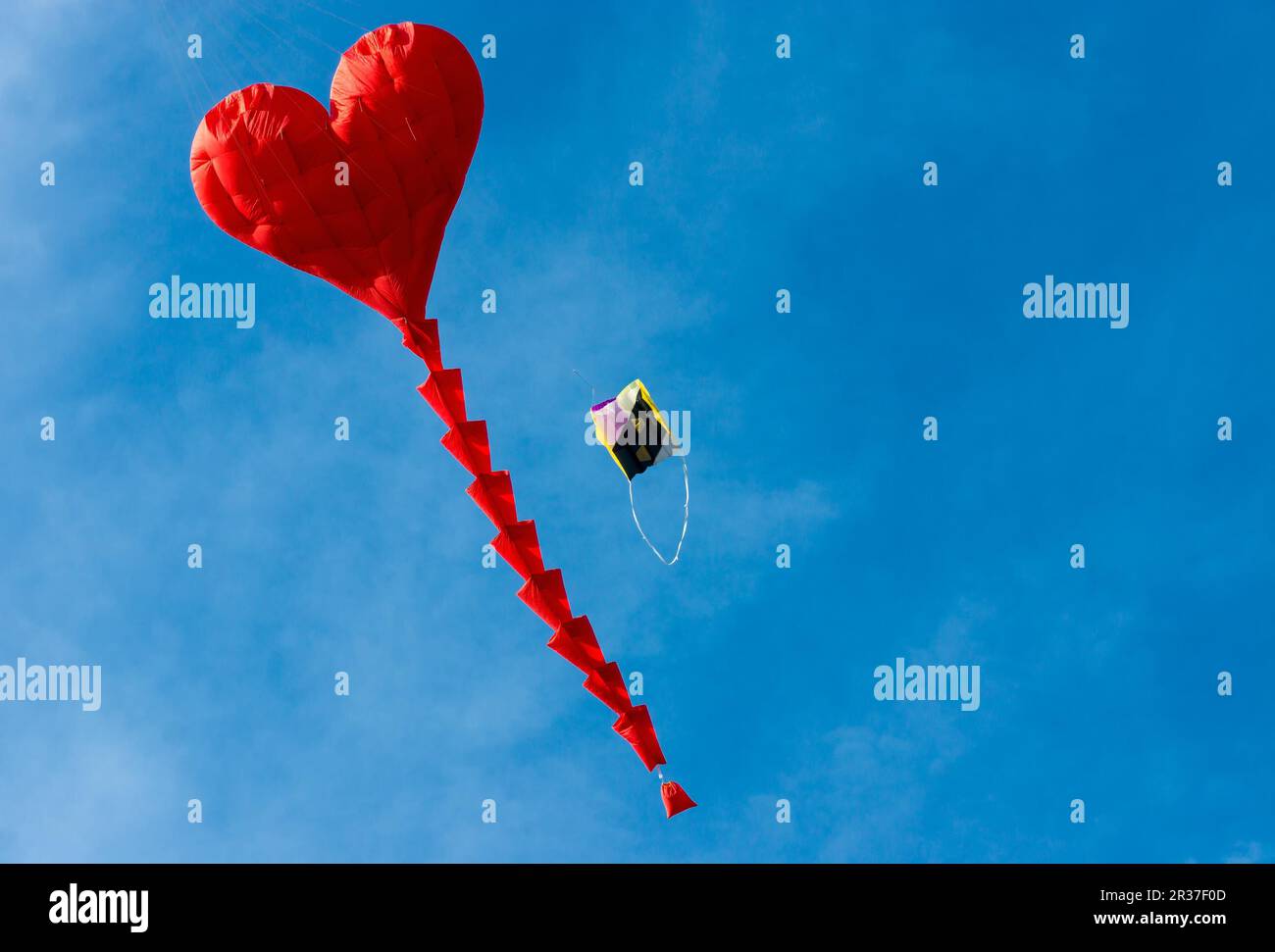 Aquilone rosso a forma di cuore contro un cielo blu Foto Stock