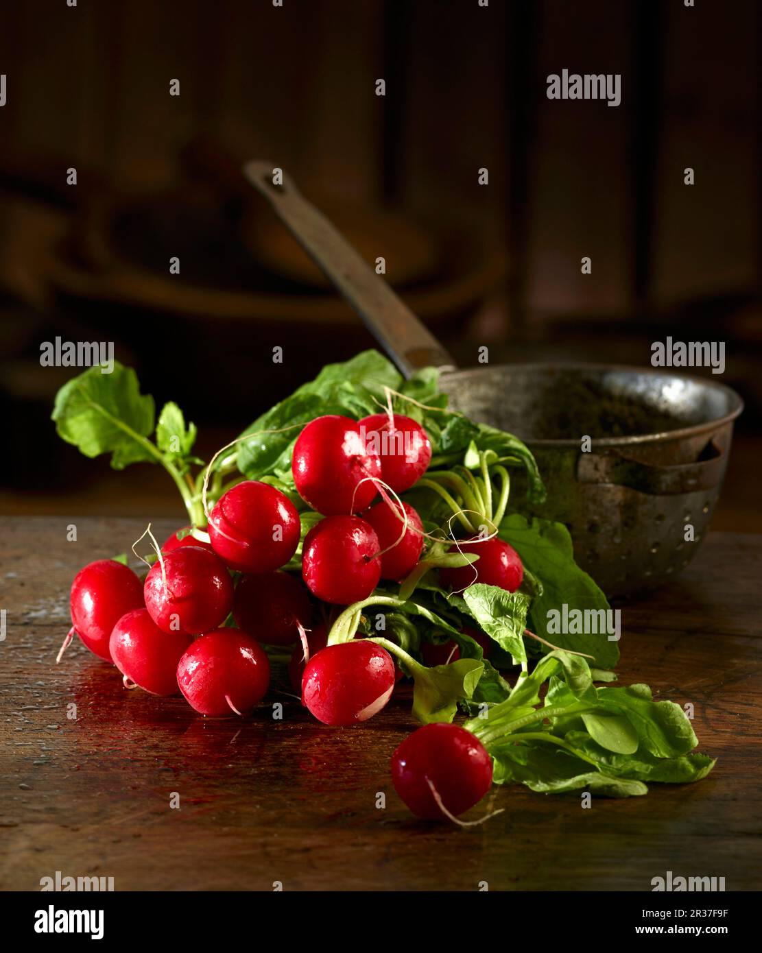 Ravanelli davanti a un vecchio setaccio da cucina Foto Stock