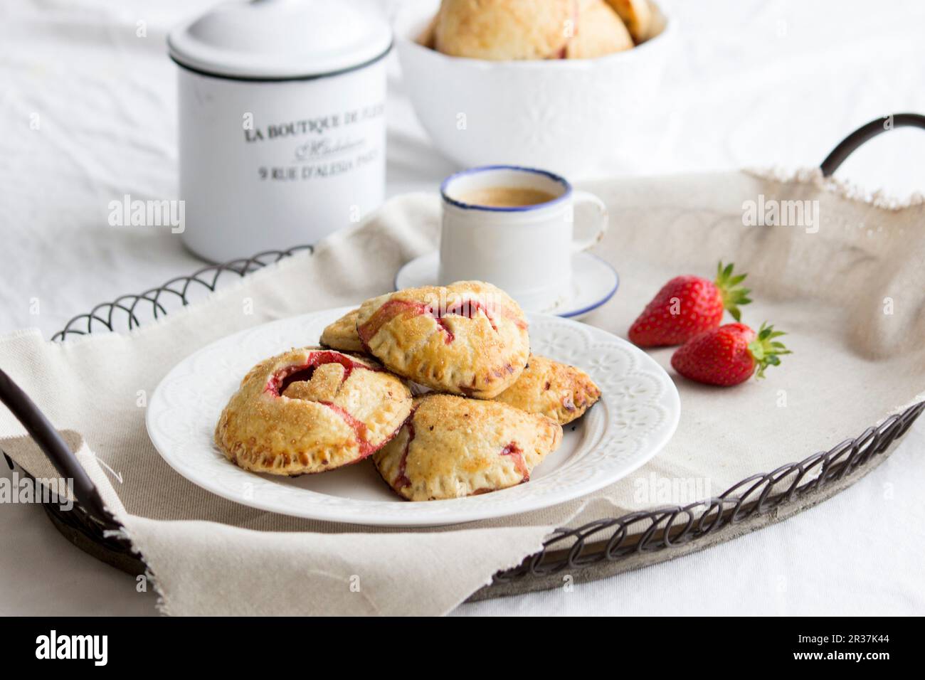 Torte di mano (mini torte) con un riempimento di fragola e decorazioni di cuore Foto Stock