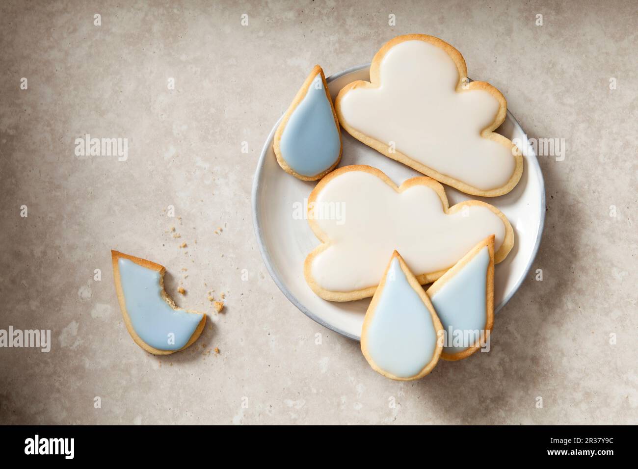 Aprile: Biscotti nuvolosa e raindrop su un piatto Foto Stock