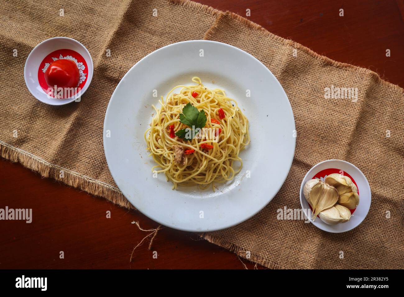 olio e olio. Pasta italiana spaghetti, aglio olio e peperoni, spaghetti con farro, olio d'oliva e peperoncini a tavola Foto Stock