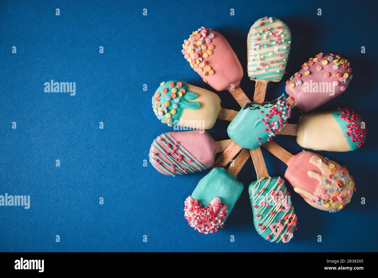 Diversi schiocchi di torte a forma di lollie di ghiaccio con glassa dai colori vivaci Foto Stock