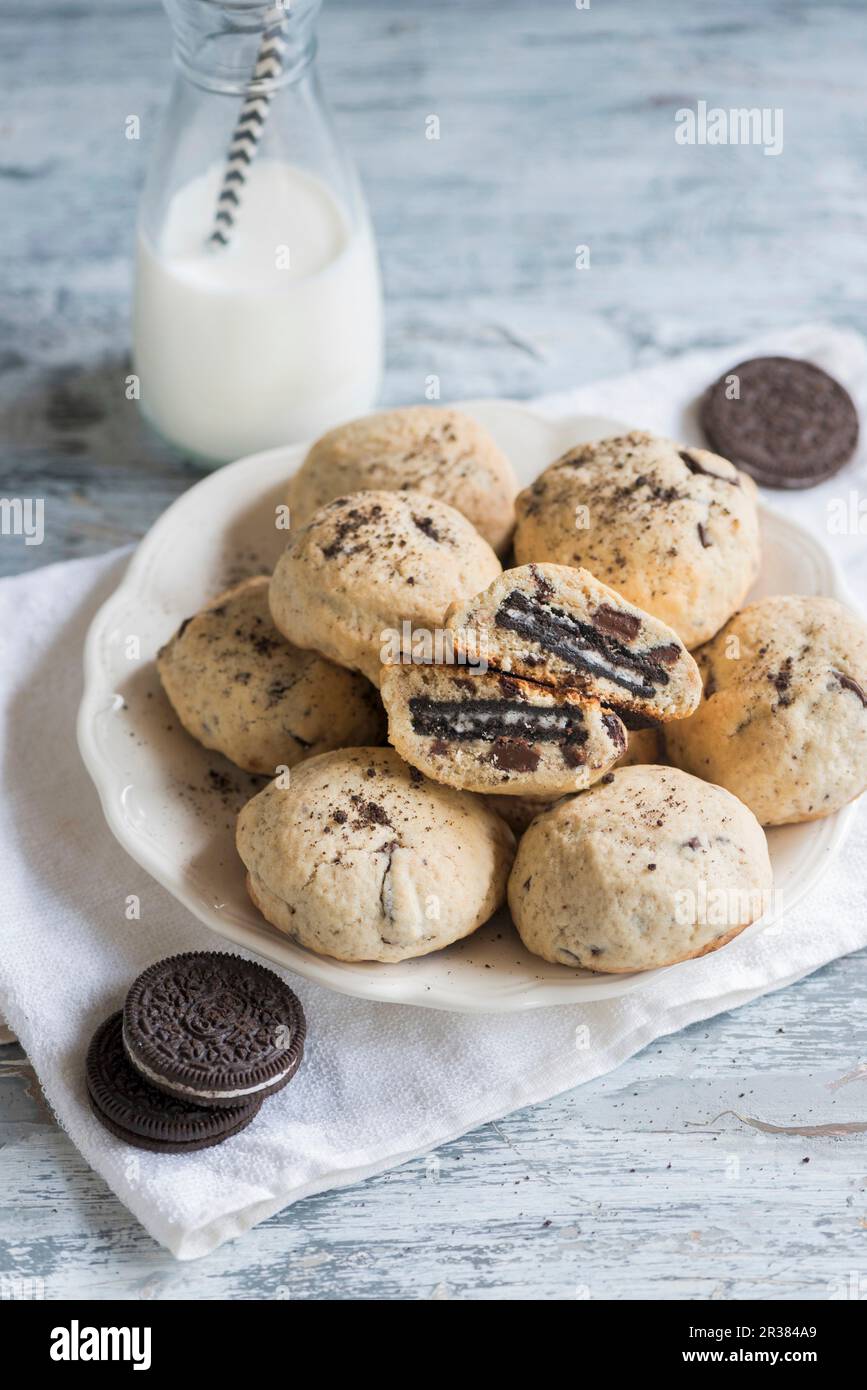 Biscotti con scaglie di cioccolato con Oreos e una bottiglia di latte Foto Stock