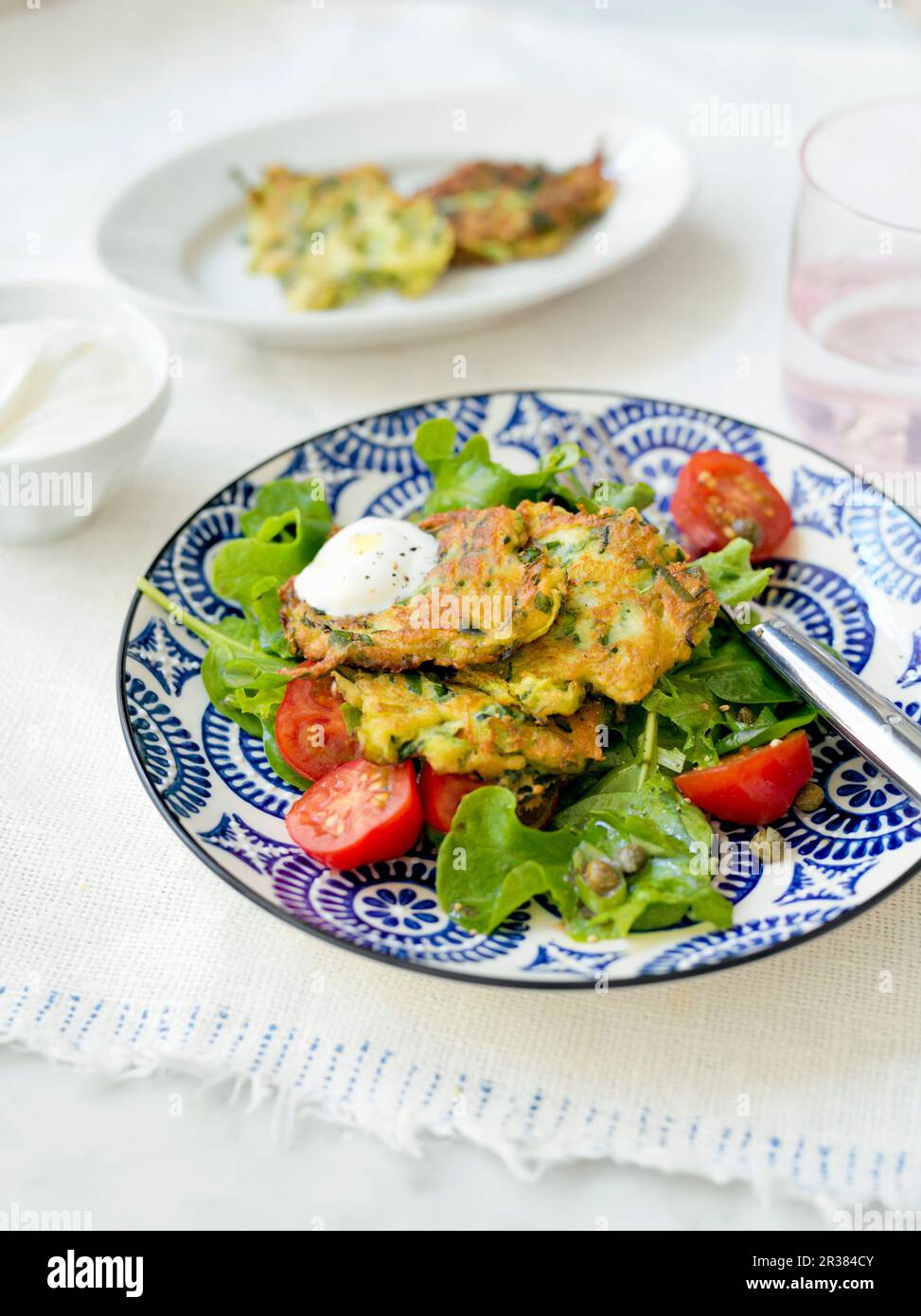 Frittelle di zucchine con spinaci e pomodori Foto Stock