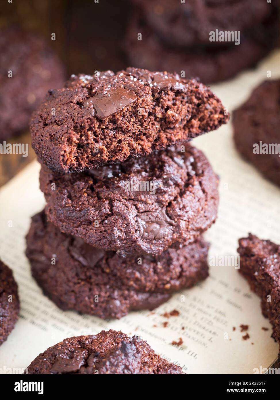 Biscotti al doppio cioccolato privi di grani (senza glutine) disposti in un mucchio, un biscotto rotto. Foto Stock