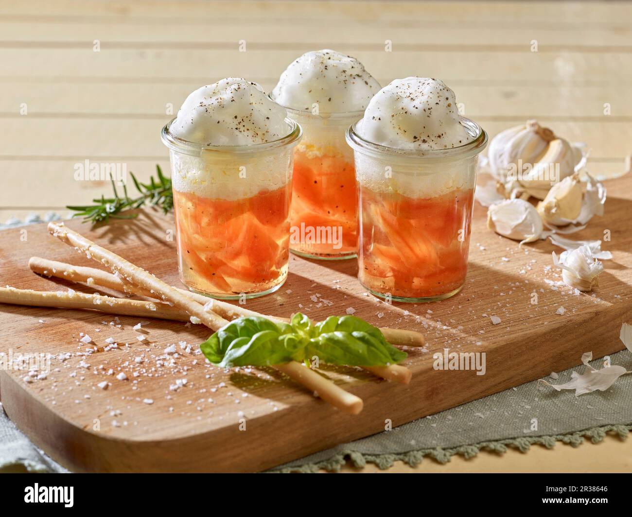 Shot di pomodoro con filetti di pomodoro tostati, schiuma di pomodoro e grissini Foto Stock