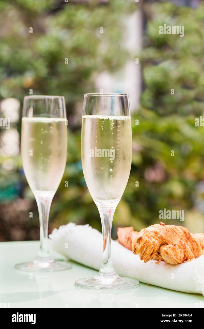 Due bicchieri di Prosecco su un tavolo esterno con grandi paillette di  formaggio Foto stock - Alamy
