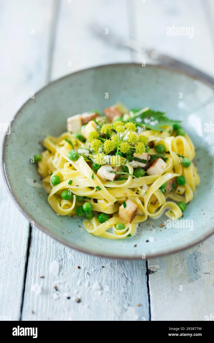 Tagliatelle a nastro con tofu affumicato e piselli Foto Stock