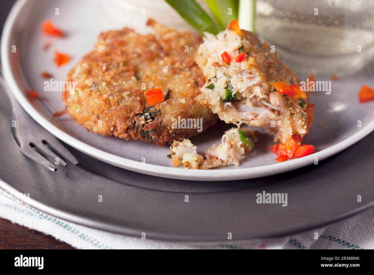 Tortine di granchio parzialmente mangiate con pepe rosso Foto Stock