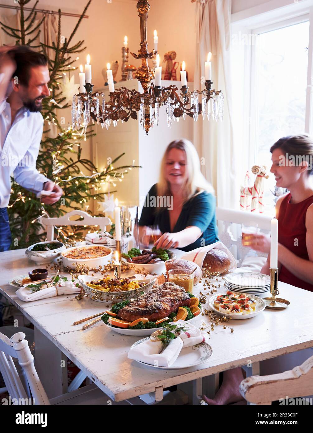 Una famiglia seduta intorno ad un tavolo per la cena di Natale Foto Stock