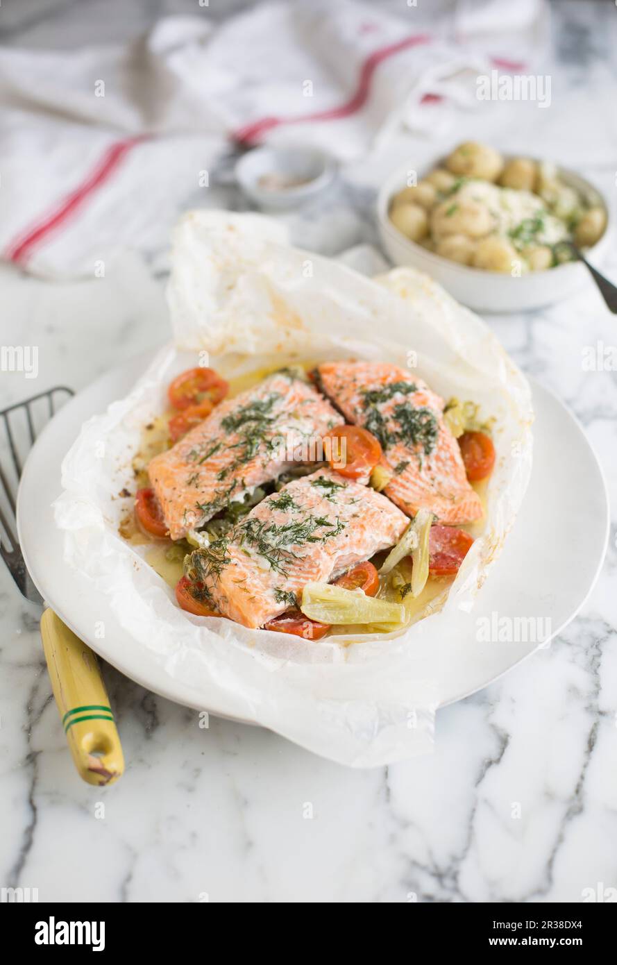 Salmone in carta pergamena con finocchio e pomodori Foto Stock