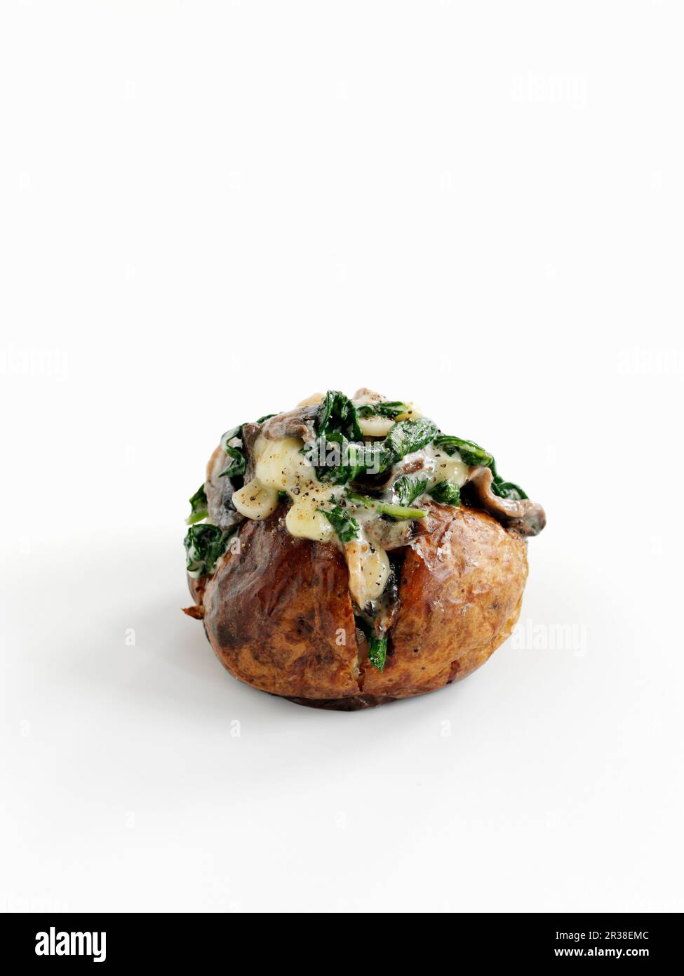 Una patata al forno con spinaci, aglio e funghi Foto Stock