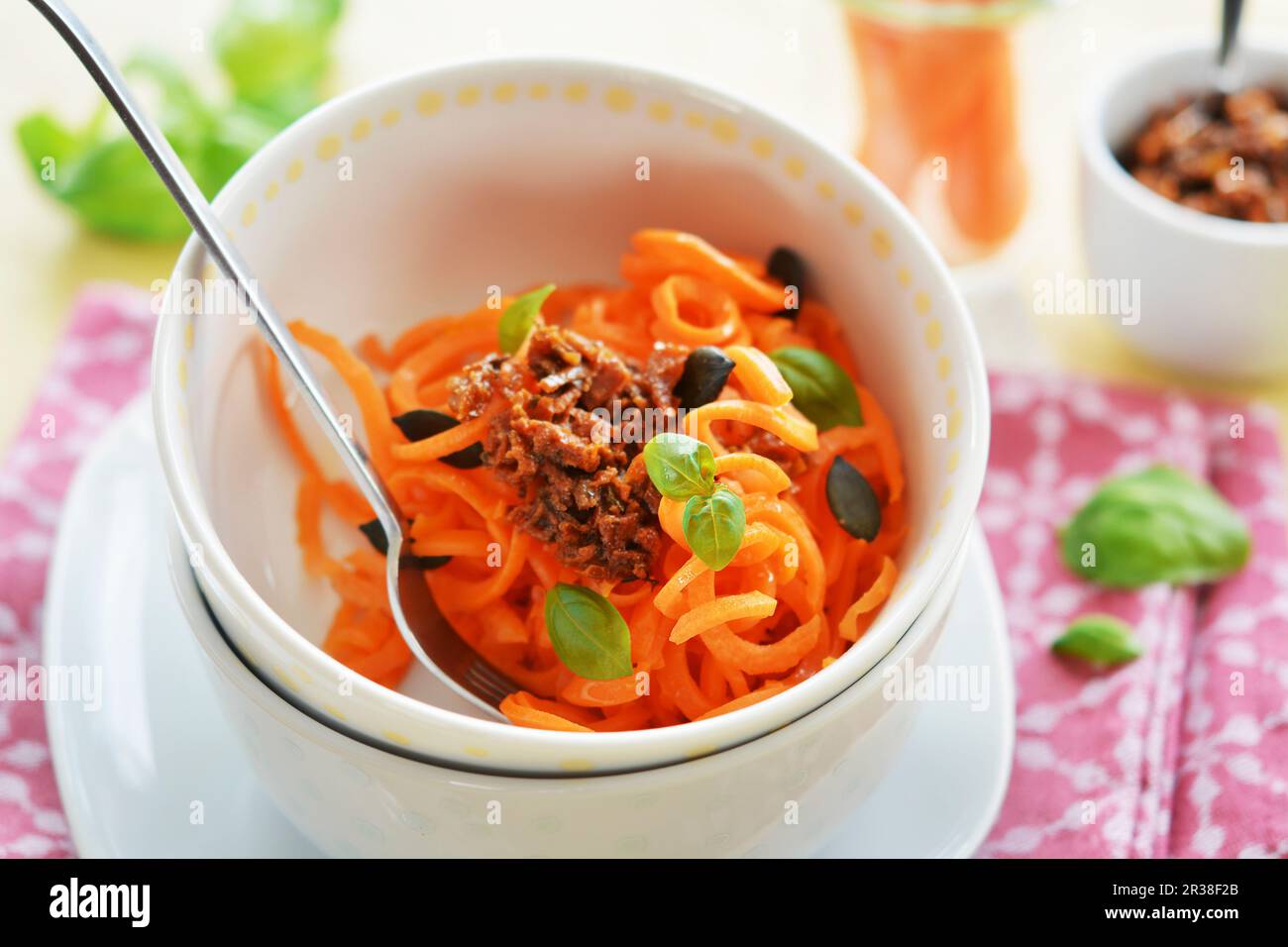 Spaghetti alle carote con pesto di pomodoro essiccato, semi di zucca e basilico fresco Foto Stock