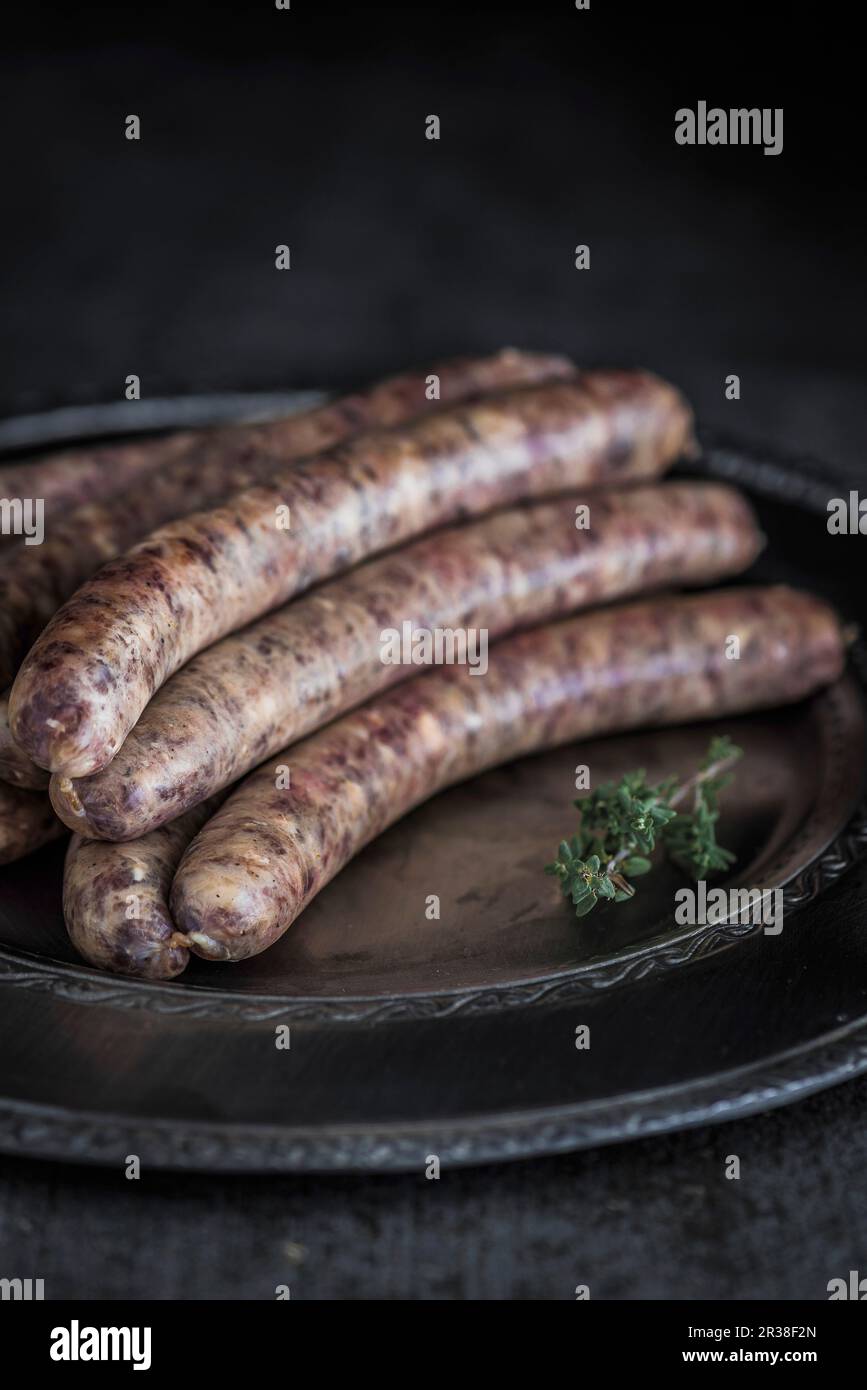 Wagyu bratwurst su un piatto da portata con un rametto di timo Foto Stock