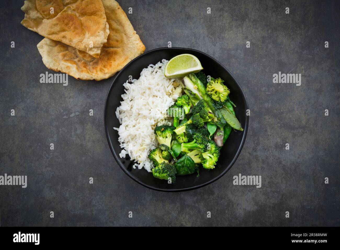 Curry thailandese verde con broccoli, bok choy, tout di manga, spinaci, lime e riso Foto Stock