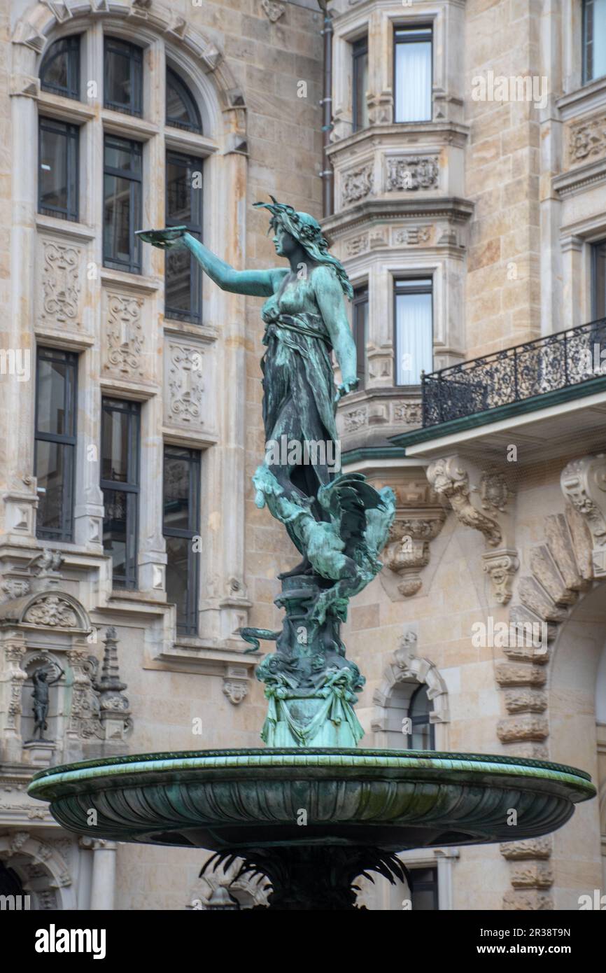Statua ornata di Donna in fontana con antico edificio dietro Foto Stock