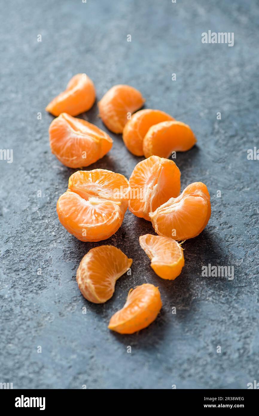 Pezzi di un mandarino su un urface di pietra Foto Stock