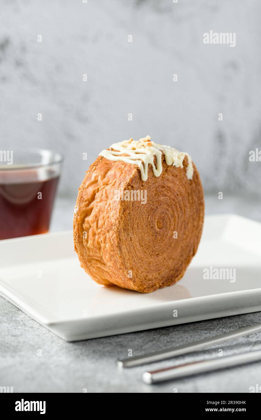 Rotolo di cioccolato New York o croissant rotondo con tè su tavolo di pietra Foto Stock